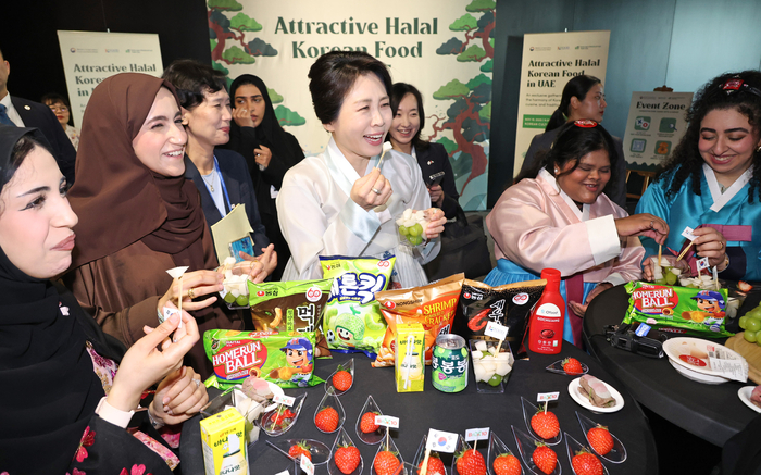 이재명 대통령과 아랍에미리트(UAE)를 국빈 방문 중인 김혜경 여사가 19일(현지시간) 아부다비 주UAE한국문화원에서 열린 할랄 K-푸드 홍보행사에서 참석자들과 한국 과자를 맛보고 있다. 연합뉴스