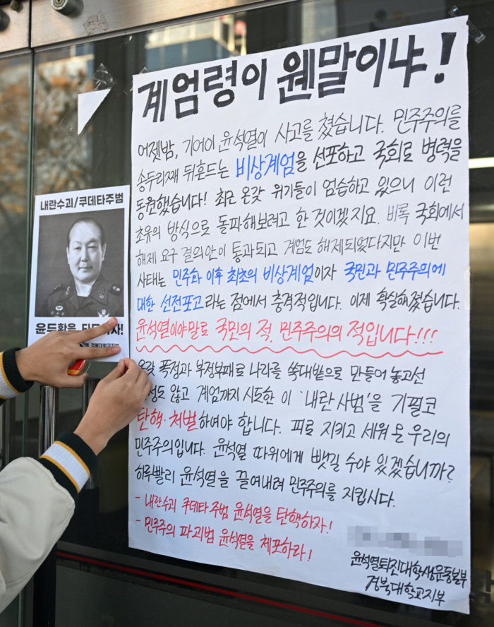 윤석열 퇴진 대학생운동본부 경북대학교지부 회원이 2024년 12월4일 대구 북구 경북대학교 인문대학 입구에 윤 대통령 탄핵을 촉구하는 대자보를 붙이고 있다. 영남일보DB