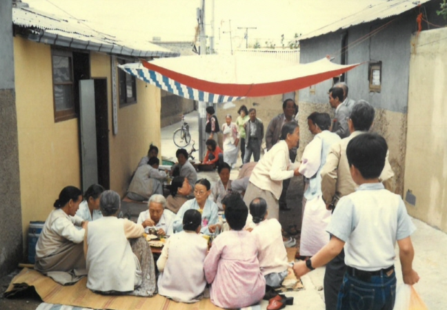 1970년대 대구 북구 복현1동 골목에서 주민들이 돗자리를 펴고 함께 마을 잔치를 즐기고 있다. 북구청 제공