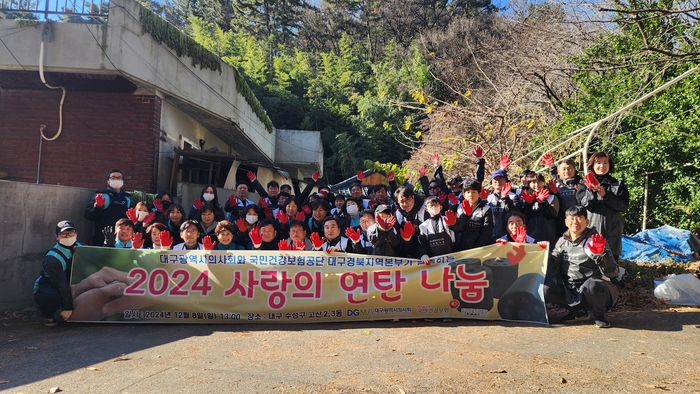 대구시의사회가 사랑의 연탄 나눔 봉사활동을 펼치며 기념촬영을 하고 있다. 참여자들이 빨간 장갑을 끼고 환하게 손을 흔들며 이번 겨울 취약계층 지원 의지를 함께 다지고 있다.<대구시의사회 제공>