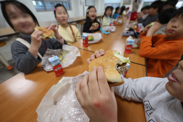 [포토뉴스] 대체급식으로 받은 햄버거 먹는 초등학생