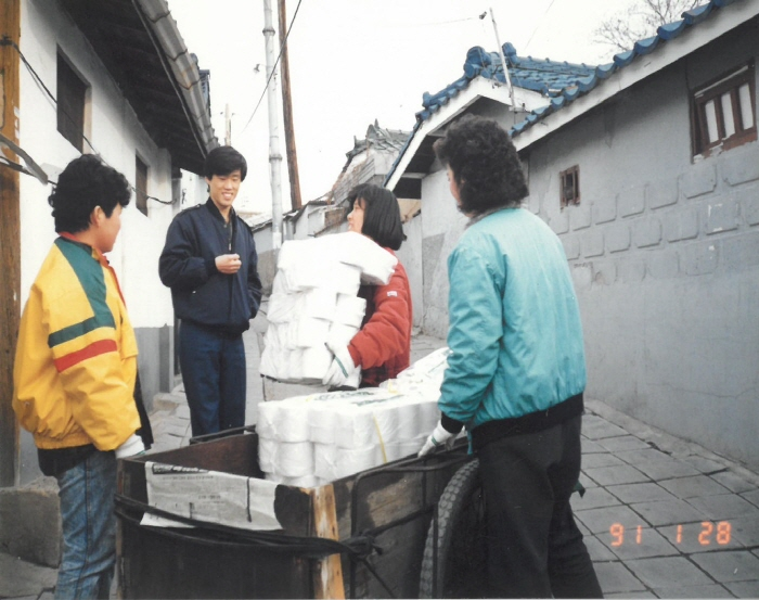 1990년대 당시 대구 북구 복현1동 골목길 모습. 한 좁은 골목 사이로 주민들이 휴지들을 옮기며 담소를 나누고 있다. 북구청 제공