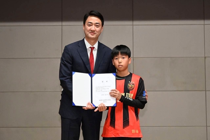 최재훈(왼쪽) 달성군수가 달성군청 유소년축구단(U-12) 창단식에서 선수 대표와 함께 선서문을 들고 기념촬영을 하고 있다.<달성군 제공>