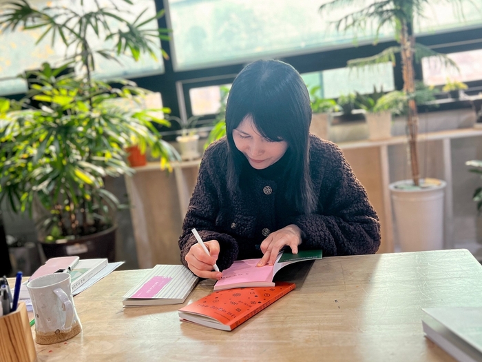 하기정 시인이 자신의 시집에 사인을 하고 있다. 하 시인은 올해 첫 산문집 건너가는 마음을 펴냈다.