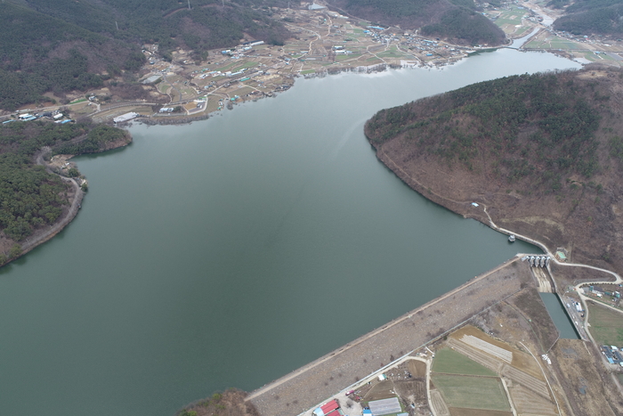 달창저수지의 제방과 방류 시설이 한눈에 보이는 항공 전경. 저수지 주변 마을과 농경지가 이어지며 지역 생활권의 중심 경관을 이룬다.<달성군 제공>