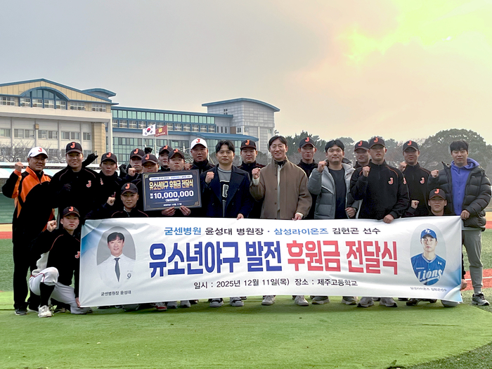 윤성대 굳센병원장과 프로야구 삼성라이온즈 김헌곤 선수가 제주고 유소년 야구 발전 후원금 전달식을 가진 뒤 기념 촬영 하고 있다.<굳센병원 제공>
