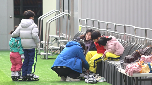 19일 아이들과 함께 팔거천 야외스케이트장을 찾은 부모들이 아이들에게 스케이트화 신겨주고 있다. 이나영 기자