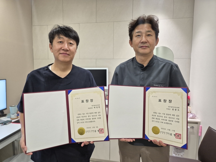 박성빈(왼쪽)·심삼도 메트로안과 원장이 지역사회 나눔과 봉사활동 공로로 표창을 받은 뒤 기념 촬영 하고 있다.<메트로안과 제공>