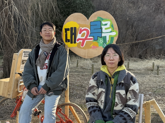 지난 18일 금호강 팔현습지 인근에 설치된 팔현습지를 지키는 예술행동 작업물에서 백승현(왼쪽) 미술감독과 감정원 감독이 포즈를 취하고 있다.  <사진=정수민기자>