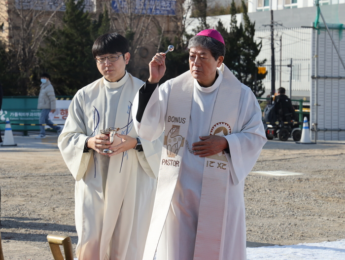 대구가톨릭대 칠곡가톨릭병원 새병원 건립 축복·기공식에서 대구대교구 조환길(타대오) 대주교가 축복 예식을 집전하고 있다. 옆에서 사제가 성수를 들고 예식을 보좌하고 있다.<칠곡가톨릭병원 제공>