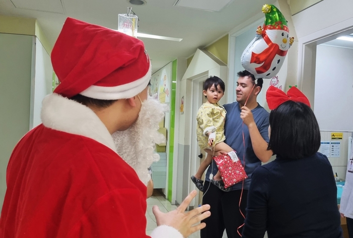 크리스마스 이브인 24일, 효성병원 아동병동에서 산타로 분장한 직원이 입원 중인 어린이에게 캐릭터 풍선을 전달하며 환한 웃음을 선사하고 있다.<효성병원 제공>