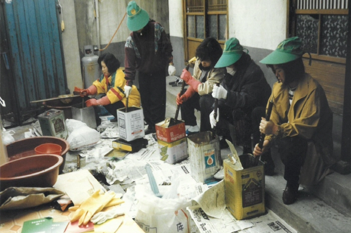 1970년대 대구 북구 복현1동에서 마을주민들이 연탄가루(깨진 연탄)와 폐유 등을 섞어 난방 연료를 만들고 있다. <북구청 제공>