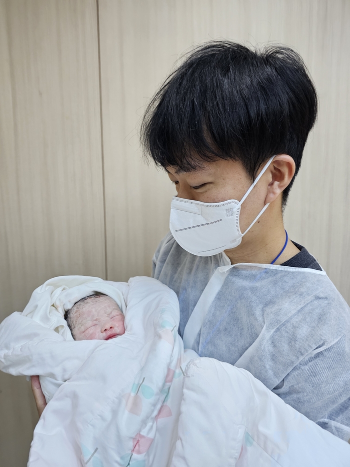 병오년 새해 첫날인 1일 오전 10시 10분, 대구 효성병원 분만실에서 태어난 첫둥이를 남편이 조심스럽게 품에 안고 있다.<효성병원 제공>