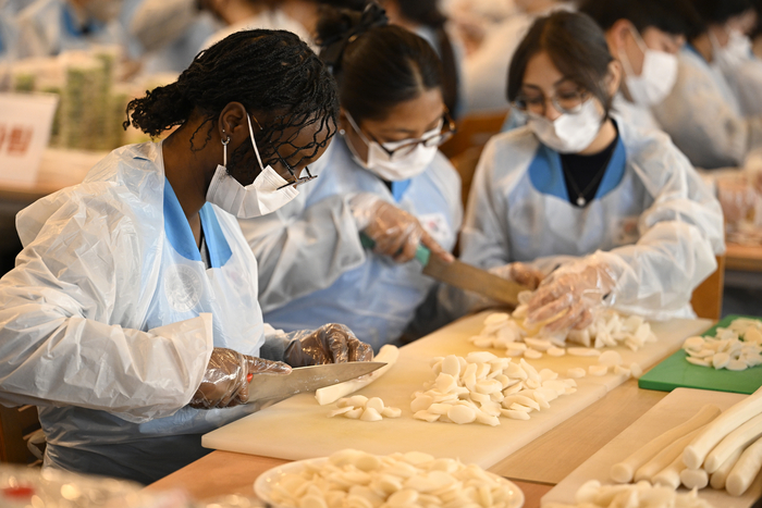 [포토뉴스] 영남대학교 사랑의 떡국 나눔 행사에서 가래떡 써는 외국인 유학생들