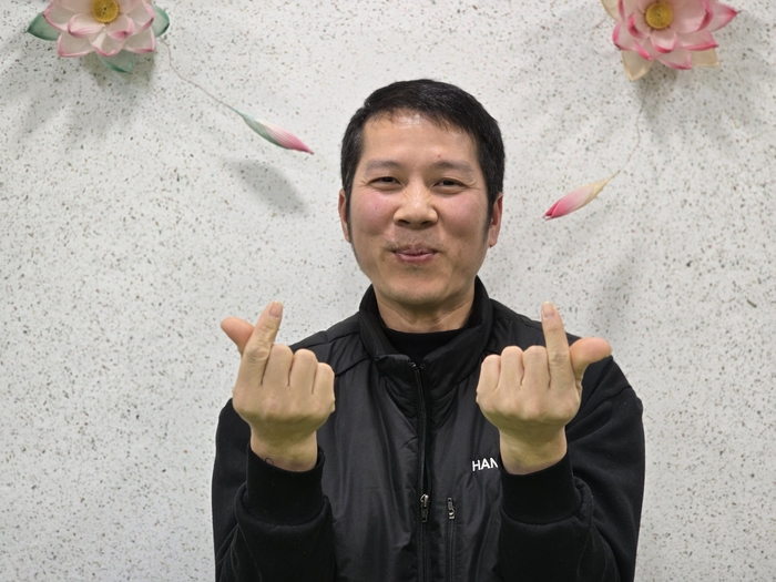 베트남 출신 뚜안씨가 부인과 베트남에 있는 세 딸을 향해 사랑의 손하트를 하고 있다. 박용기 기자