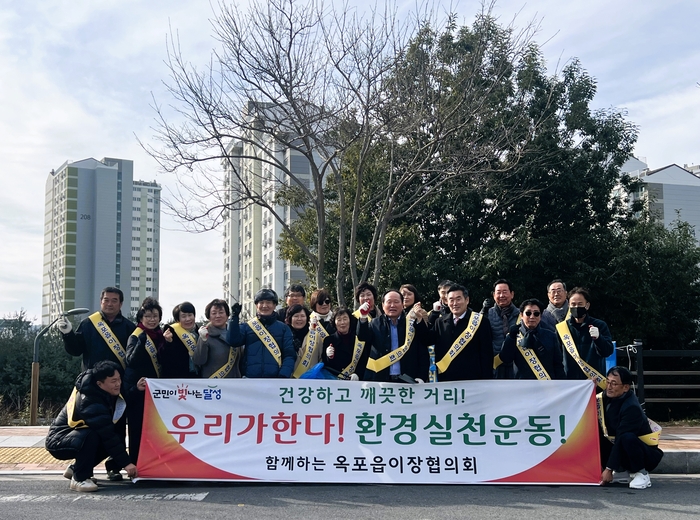 달성군 옥포읍 이장협의회 회원들이 5일 옥포지구 일원에서 환경실천운동을 벌인 뒤 건강하고 깨끗한 거리를 다짐하며 기념촬영을 하고 있다.<달성군 제공>