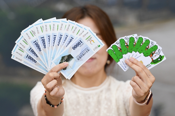 영주시민이 영주사랑상품권과 영주사랑 체크카드를 들어 보이고 있다. 영주시 제공