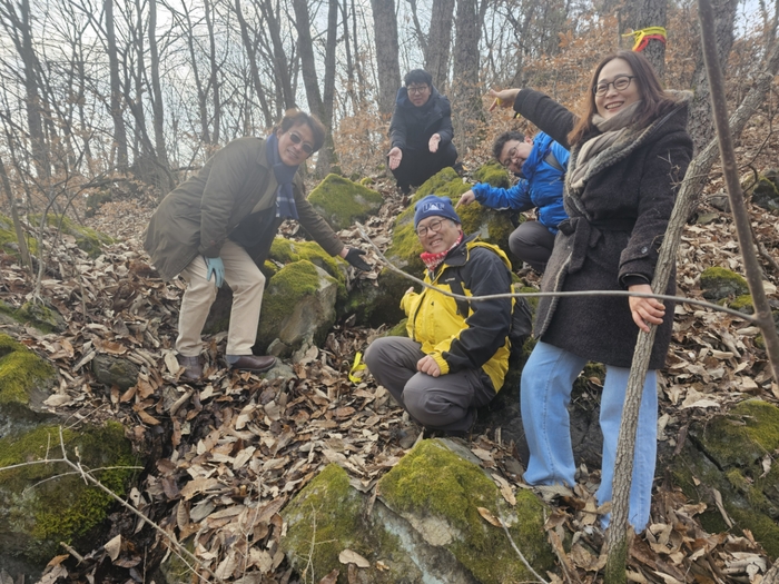 풍혈 전문가인 사와다 유키 교수(후쿠야마시립대)와 관계자들이 의성군 빙계계곡에서 발견한 온혈지대를  가르키며 기념 촬영을 하고 있다. <의성군 제공>
