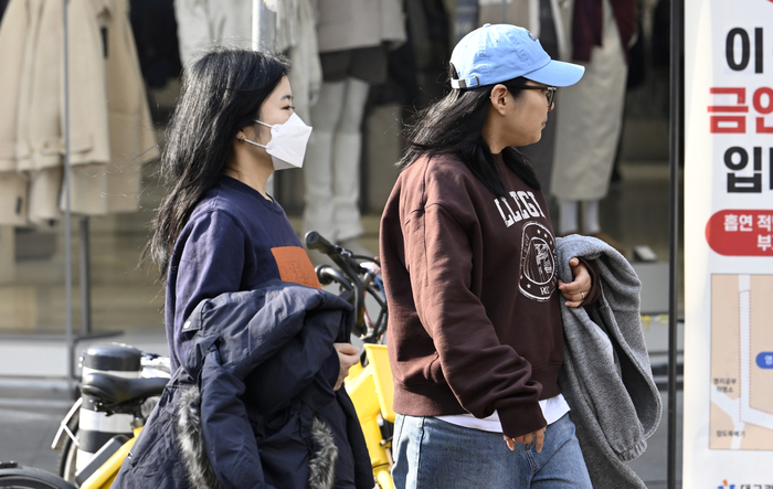 대구 낮 최고 기온 19°C로 포근한 날씨를 보인 지난 15일 오후 대구 중구 동성로를 찾은 시민들이 두꺼운 외투를 들고 이동하고 있다. 이윤호기자 yoonhohi@yeongnam.com