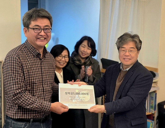 지난 16일 박진관(오른쪽) 영남일보 중부지역본부장이 사진전 수익금 500만원을 김철용 꿈을 전하는 구름물고기장학회장에게 기탁하고 있다.<꿈을 전하는 구름물고기장학회 제공>