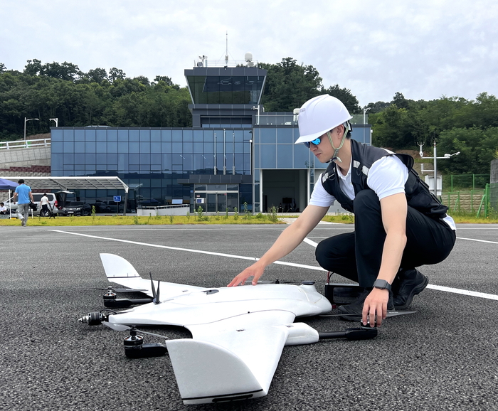 항공안전기술원 관계자가 드론비행시험센터 고정익 활주로에서 드론을 시험하기 전 기체를 점검하고 있다. <의성군 제공>