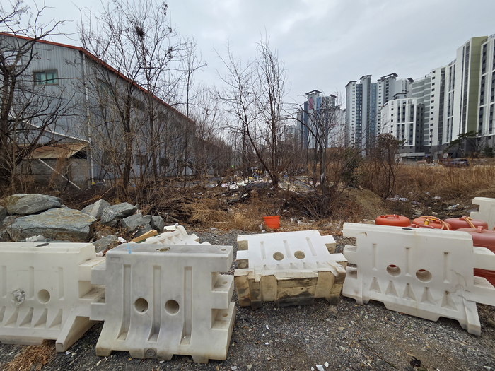 19일 대구 동구 안심뉴타운 북편 도로 2단계 구간 예정지가 각종 쓰레기와 적치물로 뒤덮인 채 방치되어 있다. 최시웅기자