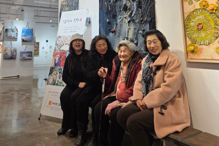 작품 앞에 나란히 앉은 이명수 여사와 전시에 참여한 세 딸.<권영애씨 제공>