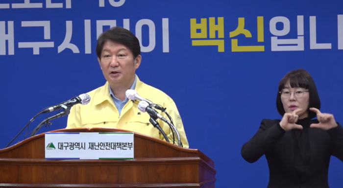 2020년 대구시청에서 열린 코로나19 정례브리핑에서 수어통역사가 당시 권영진 대구시장의 발표 내용을 수어통역하고 있다. <대구시 제공>