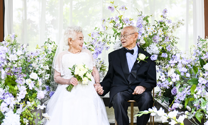 대구 팔공산 자생식물원.
연보라색 꽃들이 만개한 숲속 정원에서, 흰 웨딩드레스와 검은 턱시도로 단장한 노부부가 나란히 앉았다. 신부는 하얀 부케를 들었고, 신랑은 단정한 나비넥타이에 흰 장미를 달았다. 마주 보며 웃는 두 얼굴 사이로 긴 세월을 건너온 사연이 고요히 흐르고 있었다.

1950년, 한국전쟁이 발발하던 해. 신랑 이위영 씨와 신부 박차교 씨는 결혼식을 올렸다. 그러나 신혼의 단꿈은 징집 명령에 꺾였고, 얼굴도 익히지 못한 채 전선과 후방으로 갈라졌다. 여섯 해를 그렇게 떨어져 지내는 동안, 함께한 사진 한 장 남기지 못했다.

6월 7일, 호국보훈의 달을 맞아 마련된 국립공원 숲 결혼식에서 두 사람은 신혼 시절 남기지 못했던 사진을 75년 만에 새로 남겼다. 이처럼 삶으로 평화의 소중함을 증명해 온 참전용사 한 사람, 한 사람의 이야기는 지금도 조용히 역사의 뒷면으로 사라지고 있다. 이제 3만여 명 남은 생존자들의 삶을 기록하고, 마땅한 예우로 응답해야 할 때다.