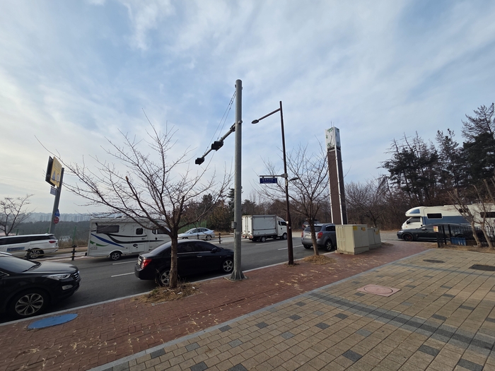 초곡지구 서편의 도로가 끊긴 채 주차장으로 변해 있다. 이 곳은 초곡 서편도로(중1-205)가 지어질 예정지로, 멀리 이인지구가 보인다. <전준혁 기자>