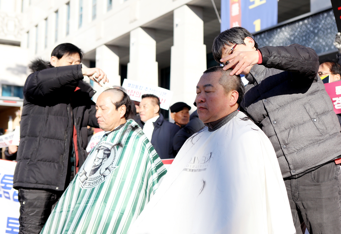 9일 오전 9시 경북도청 전정에서 황해득 비대위 사무국장(오른쪽)과 김상선 중앙신시장상인회장이 경북·대구 행정통합 재검토를 촉구하며 삭발 투쟁을 벌이고 있다. 피재윤 기자