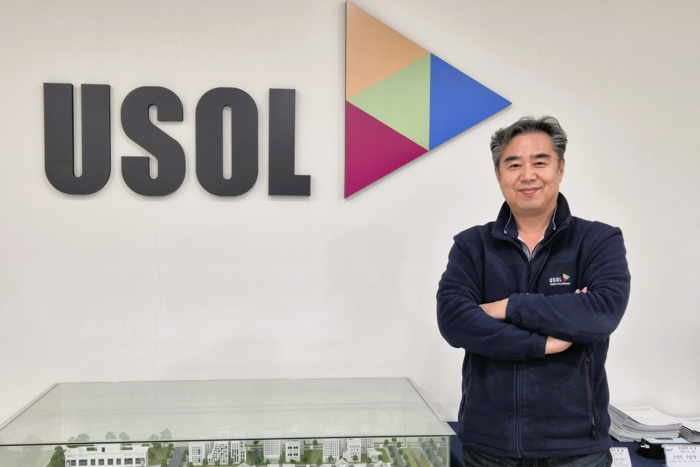 오광석 <주>유솔 대표가 자사 브랜드 로고 앞에서 포즈를 취하고 있다. <이승엽기자>