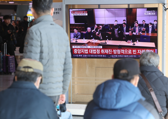 12·3 비상계엄과 관련해 내란 우두머리 혐의로 기소된 윤석열 전 대통령에 대한 1심 선고가 열린 19일 서울역에서 시민들이 관련 뉴스를 보고 있다. 연합뉴스
