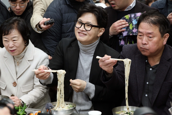 한동훈 국민의힘 전 대표가 27일 오후 대구 서문시장을 찾은 자리에서 일행들과 국수를 먹고 있다. 연합뉴스