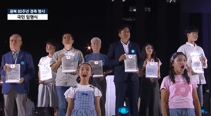 지난해 광복 80주년 국민대표 80명에 선정된 김용덕 자연보호중앙연맹 회장(가운데 정장차림)이 이재명 대통령으로부터 임명장을 수여받은 행사에 참여했다. <자연보호중앙연맹 제공>