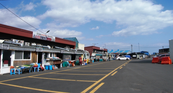 동방파제 어귀에는 수산물을 판매하는 가게들이 일자로 늘어서 있다. 뒤편에 바다에 면한 야외 포장마차가 늘어서 있고 내부 좌석도 있다.