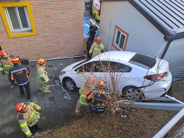 6일 오후 경북 문경시 점촌로 문경유치원 인근 도로에서 승용차가 도로 아래 유치원 건물 인근으로 추락하는 사고가 발생한 가운데, 출동한 소방대원들이 현장에서 사고 차량 주변을 확인하며 안전 조치를 하고 있다. <강남진 기자>