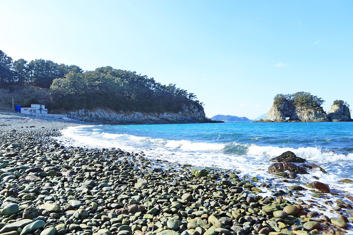 우도의 몽돌 해안과 철썩이는 파도 구멍섬의 비경. 목섬은 간조 시 섬과 섬 사이의 여울목이 목과 같이 드러난다.