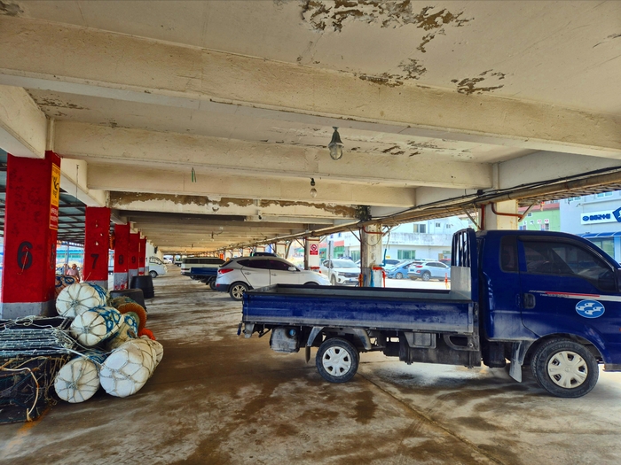 오징어로 가득차야할 울릉도 저동항 위판장에 차량들만 가득차 있다. 홍준기 기자