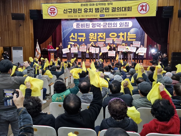 이번엔 반드시 유치하자! 14일 영덕군민회관에서 열린 영덕 신규 원전 유치 범군민 결의대회에서 참석 주민들이 사회단체장들과 함께 손팻말을 들고 원전 유치를 촉구하는 구호를 외치고 있다.