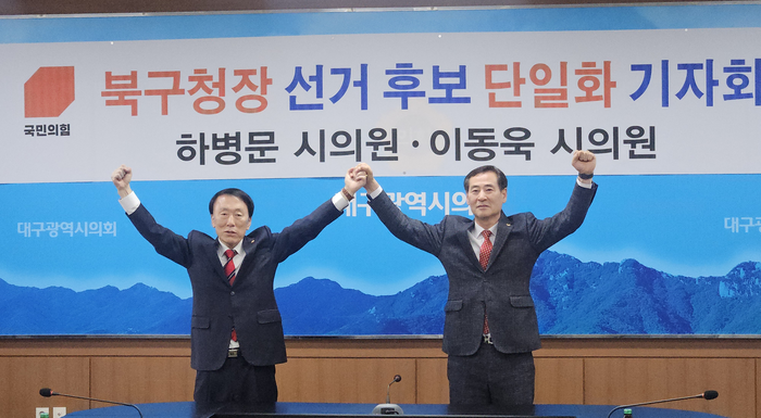 대구 북구청장 선거에 도전장을 내민 하병문(왼)·이동욱(오) 대구시의원이 18일 기자회견을 열고 여론조사를 통해 단일 후보를 결정하겠다는 기자회견을 열고 파이팅을 외치고 있다. 서민지기자