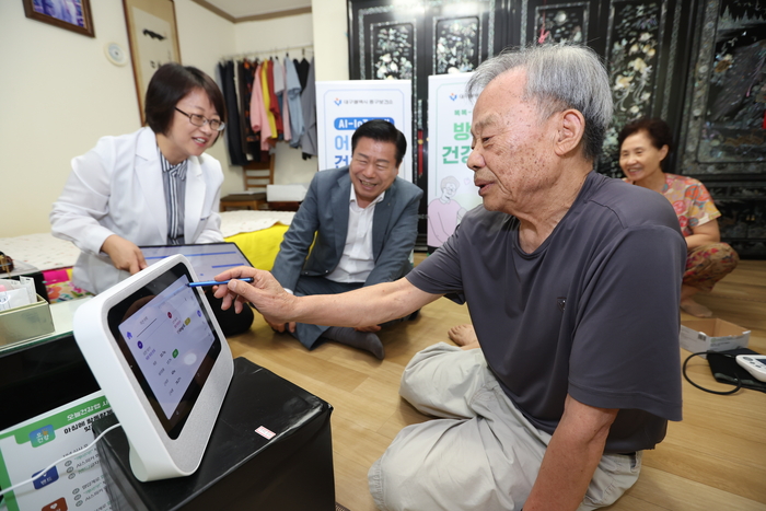 대구 중구 AI·IoT 기반 비대면 건강관리 서비스에 참여한 어르신이 건강관리기기를 활용해 건강상태를 확인하고 있다. <중구청 제공>