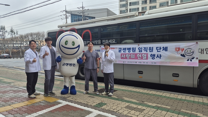 굳센병원 의료진이 본원 앞에 마련된 헌혈 버스에서 단체 헌혈 행사를 마친 뒤 기념 촬영을 하고 있다.<굳센병원 제공>