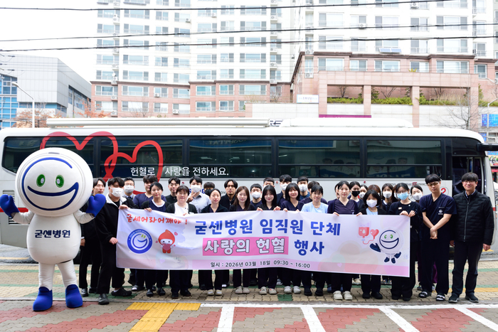 굳센병원 앞마당에서 열린 임직원 단체 사랑의 헌혈 행사에서 병원 마스코트인 굳센이와 임직원들이 헌혈 버스 앞에서 기념 촬영을 하고 있다.<굳센병원 제공>