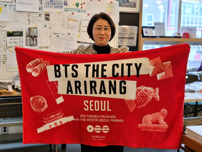 CMA글로벌 김영선 대표가 지난 21일 서울 광화문에서 컴백 무대를 가진 방탄소년단(BTS) 굿즈(비치타월)를 펼쳐보이고 있다. 이승엽기자