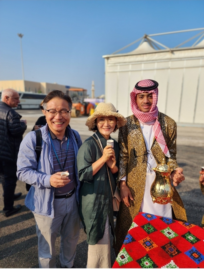 조상열씨가 중동 크루즈 여행 중 사우디아라비아 입국 심사를 통과한 뒤, 현지 청년의 환영 속에 대추야자와 사우디 커피를 나누며 남편과 함께 기념사진을 남기고 있다. 조상열씨 제공