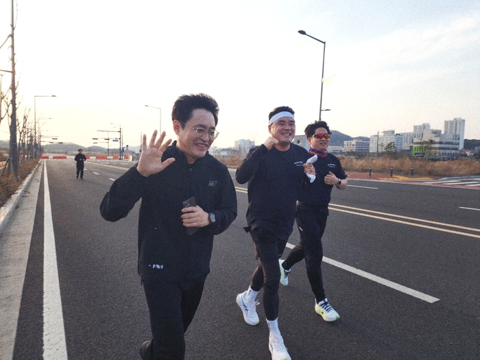 지난 23일 예천군 호명읍 경북도서관 뒤편 도로에서 농협중앙회 경북본부 러닝 동호회 난닝구(NANNINGGU) 러닝크루에 참여한 김긴욱 경북농협은행 본부장(왼쪽 첫번째)과 김종필 경북농협 노조위원장(가운데)이 화이팅하며 달리고 있다. <장석원 기자>