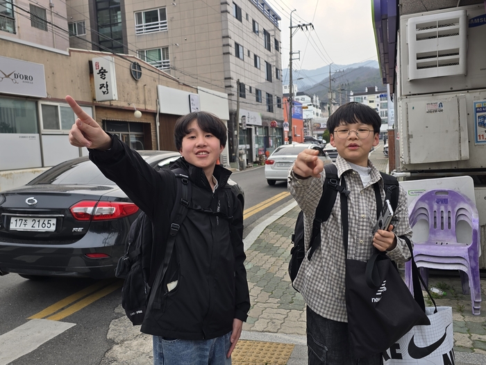 이서준(왼쪽) 학생과, 이예준 학생이 손수레를 끌기 시작한 지점을 설명하고 있다. <박용기 기자>