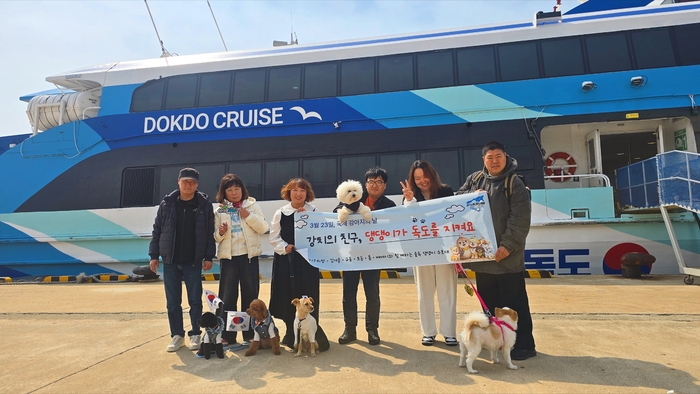 지난 23일 국제강아지의 날을 맞아 반려견과 함께 울릉도.독도를 찾은 울독 댕댕이 수호대가 독도 여객선 앞에서 기념촬영을 하고 있다. 홍준기 기자