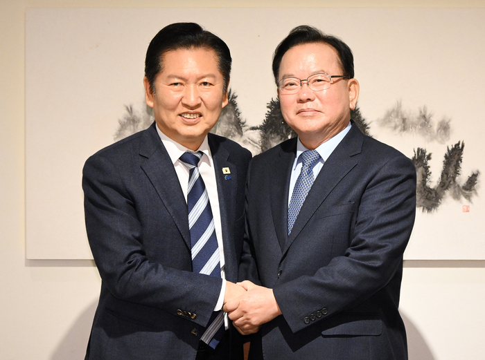 더불어민주당 정청래 대표와 김부겸 전 국무총리가 26일 서울 중구 달개비에서 회동 전 손을 맞잡고 있다.  연합뉴스